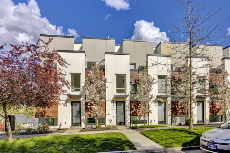 Modern townhouse complex in Madison Valley neighborhood of Seattle, Washington. Complex is set back from street with sidewalks in front and on-street parking.