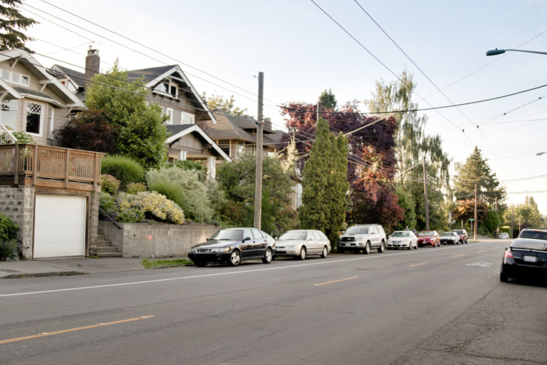 Residential neighborhood street in Madrona neighborhood of Seattle, Washington. Houses are set back from street with terraced yards and also have on-street parking