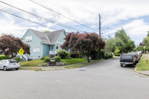 Single family home in Portage Bay Roanoke neighborhood of Seattle, Washington. House has mature landscape on sloping yard.