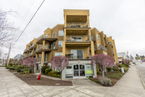 Four-story condominium complex with retail and mixed-use first floor in Des Moines-Normandy Park neighborhood of Seattle, Washington.