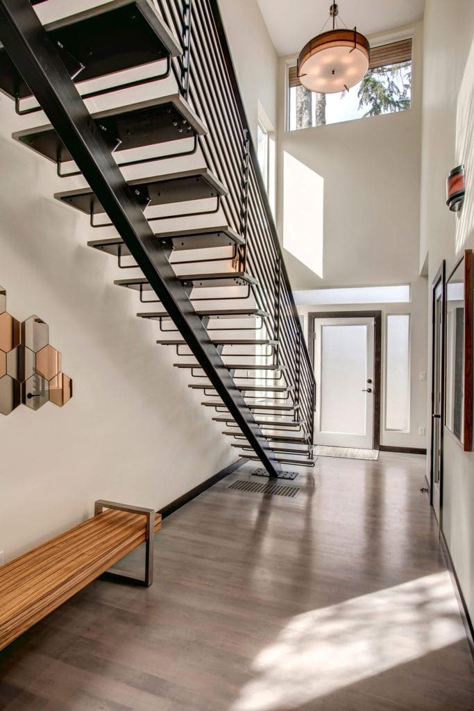 Architecturally dramatic steel staircase showcases the two story entryway.