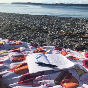 Picture of blankets on the beach with a writing journal on top