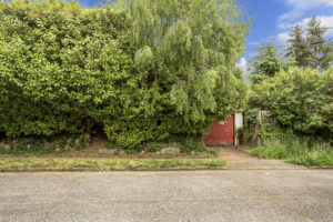 Picture of overgrown front yard and garage of scary house