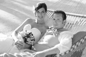 photo of groom and bride lying in a hammock