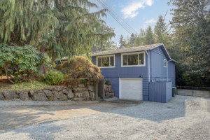 Kenmore Mid Century Home Garage and Driveway blue house surrounded by trees