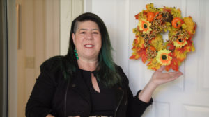 Kim Colaprete posing in front of a wreath