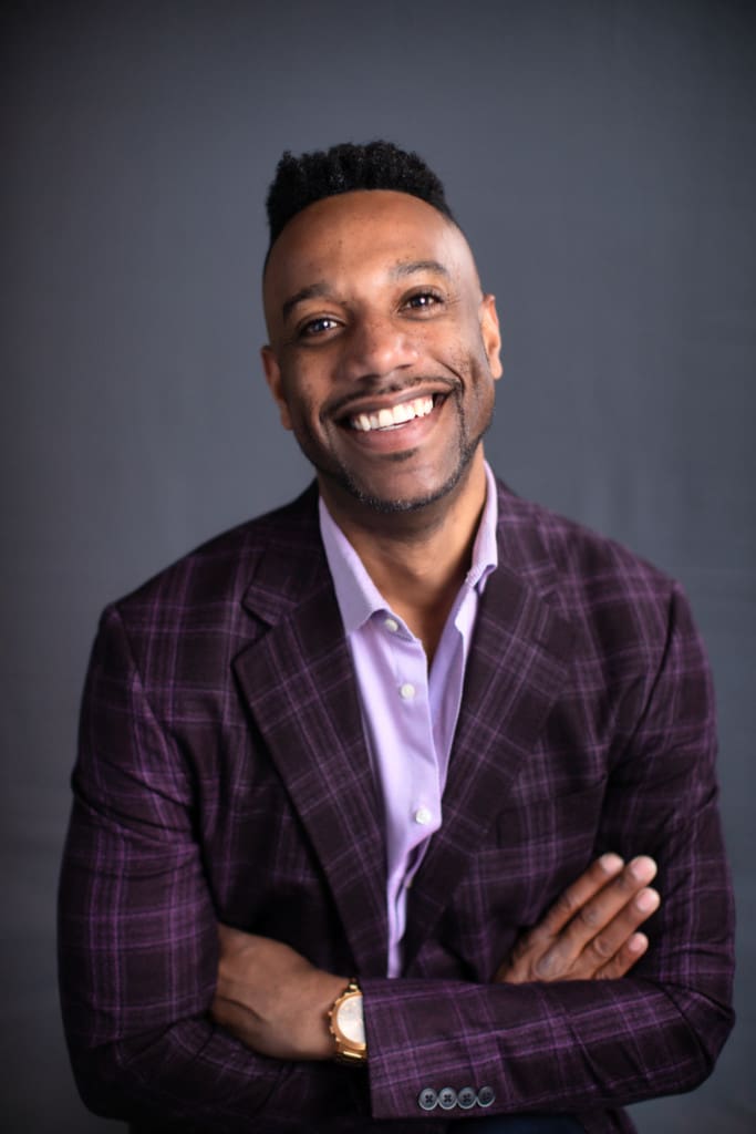 Rocky Flowers posing in a purple plaid suit