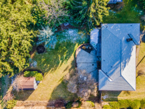 Drone view of home in Bothell showing house, patio, and landscaped backyard.