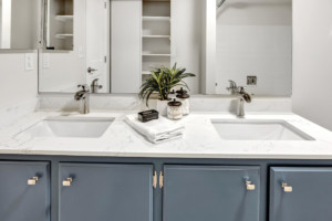Bathroom double sinks with marble counter and cabinets