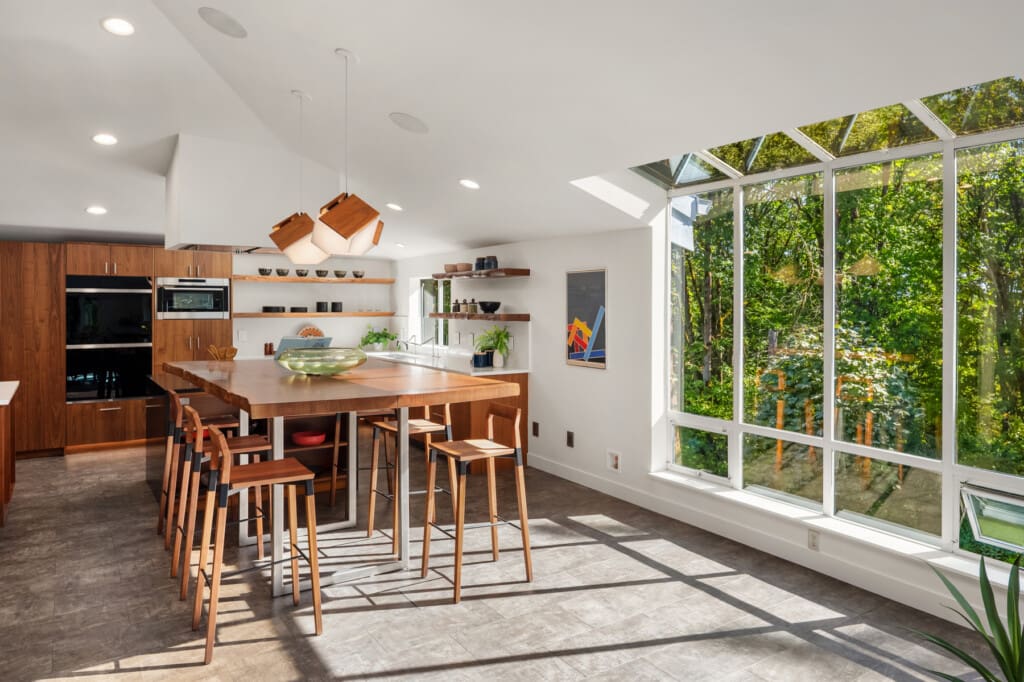 Oversized remodeled kitchen with black walnut cabinets and a live edge walnut dining table in Redmond