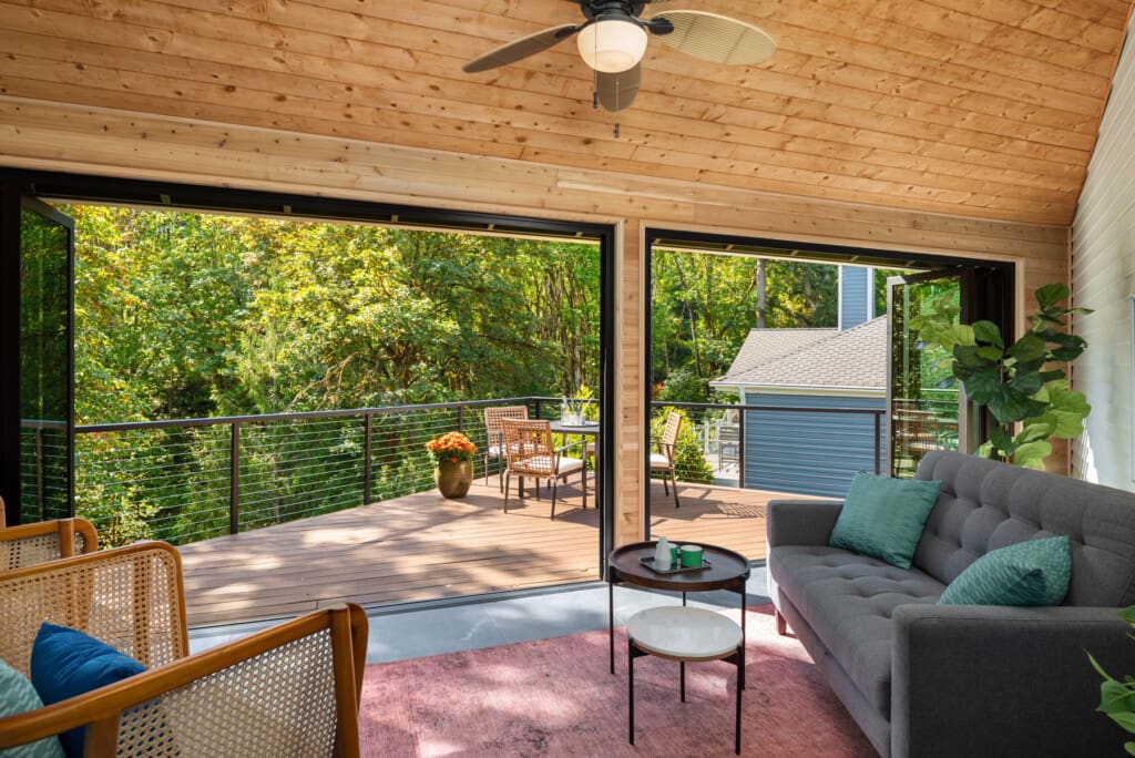 Refurbished sunroom with wall-to-wall Nana doors opening to the deck
